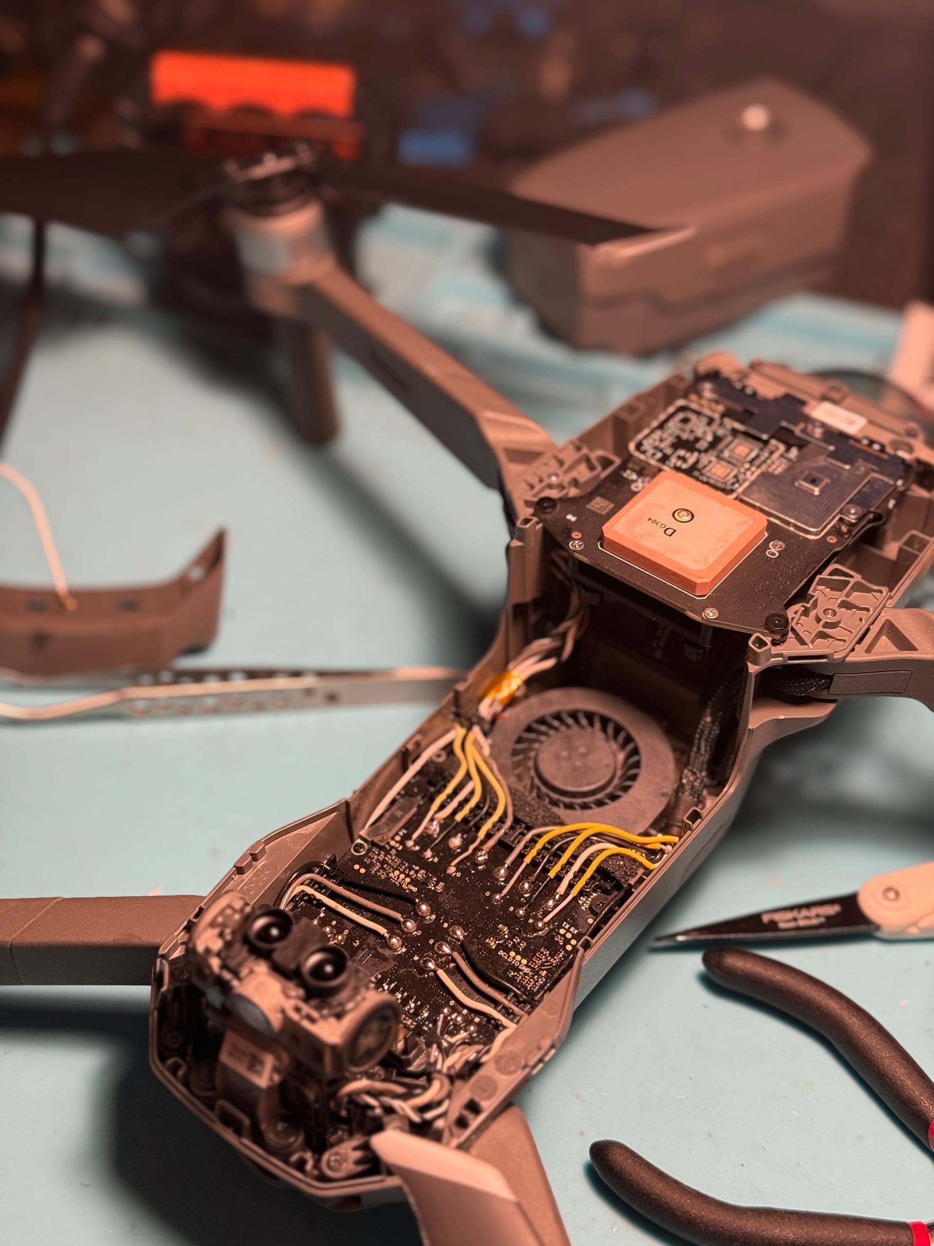 Réparation drone DJI à Poitiers — carte électronique démontée sur établi avec outils de microsoudure
